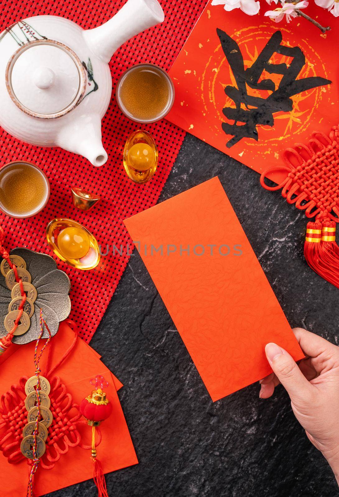 Design concept of Chinese lunar January new year - Woman holding, giving red envelopes (ang pow, hong bao) for lucky money, top view, flat lay, overhead above. The word 'chun' means coming spring. by ROMIXIMAGE