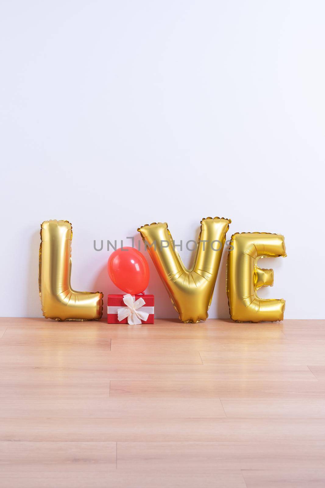 Valentine's day, Mother's day design concept - Beautiful balloon with word love shape on a light wooden floor and white wall background, close up.