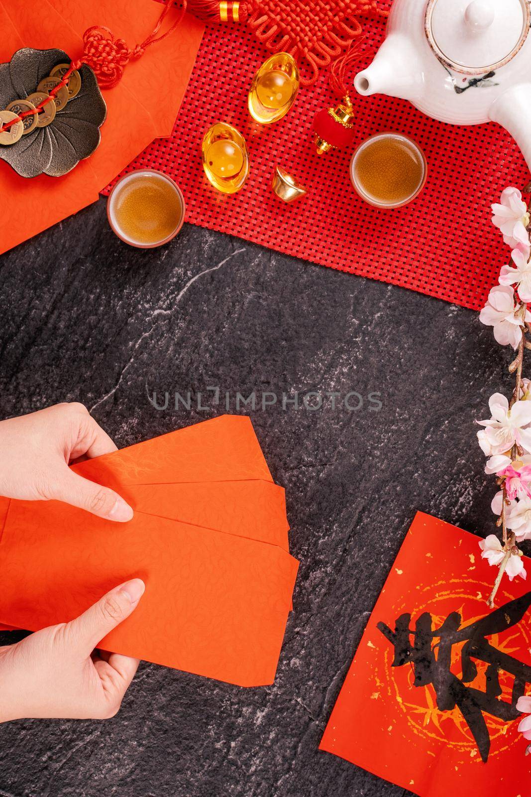 Design concept of Chinese lunar January new year - Woman holding, giving red envelopes (ang pow, hong bao) for lucky money, top view, flat lay, overhead above. The word 'chun' means coming spring. by ROMIXIMAGE