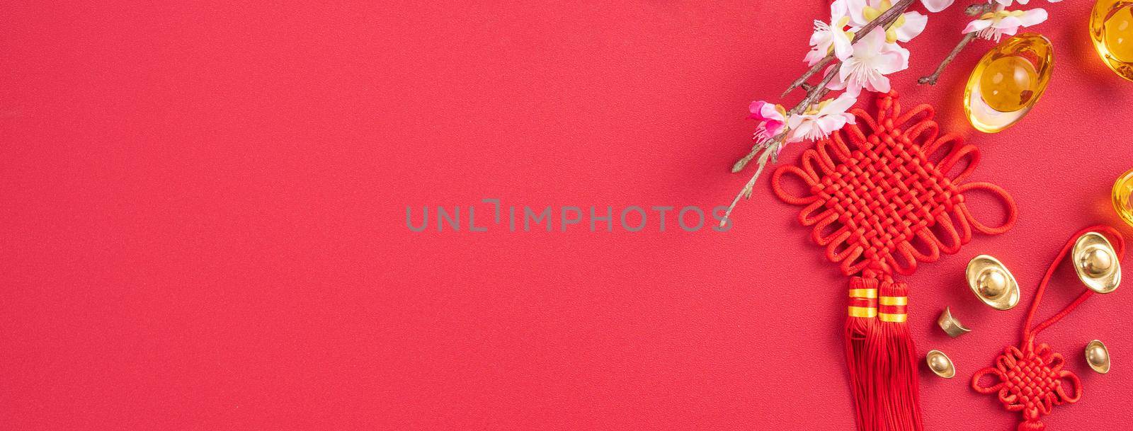 Design concept of Chinese lunar new year - Beautiful Chinese knot with plum blossom isolated on red background, flat lay, top view, overhead layout. by ROMIXIMAGE