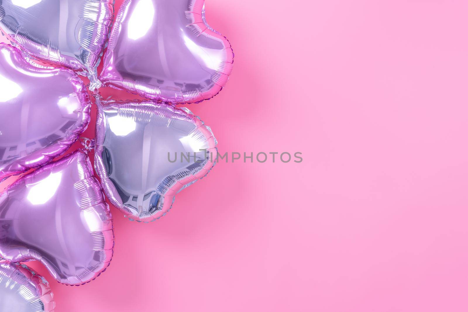 Valentine's Day minimal design concept - Beautiful real heart shape foil balloon isolated on pale pink background, top view, flat lay, overhead above photography.