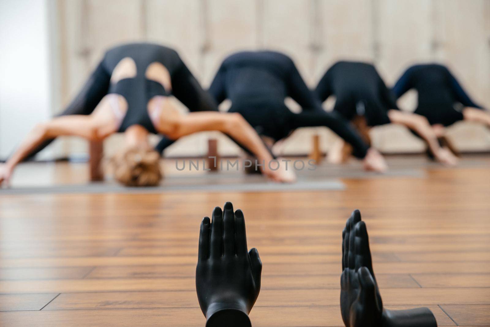 Group of women practicing yoga stretching using wooden blocks