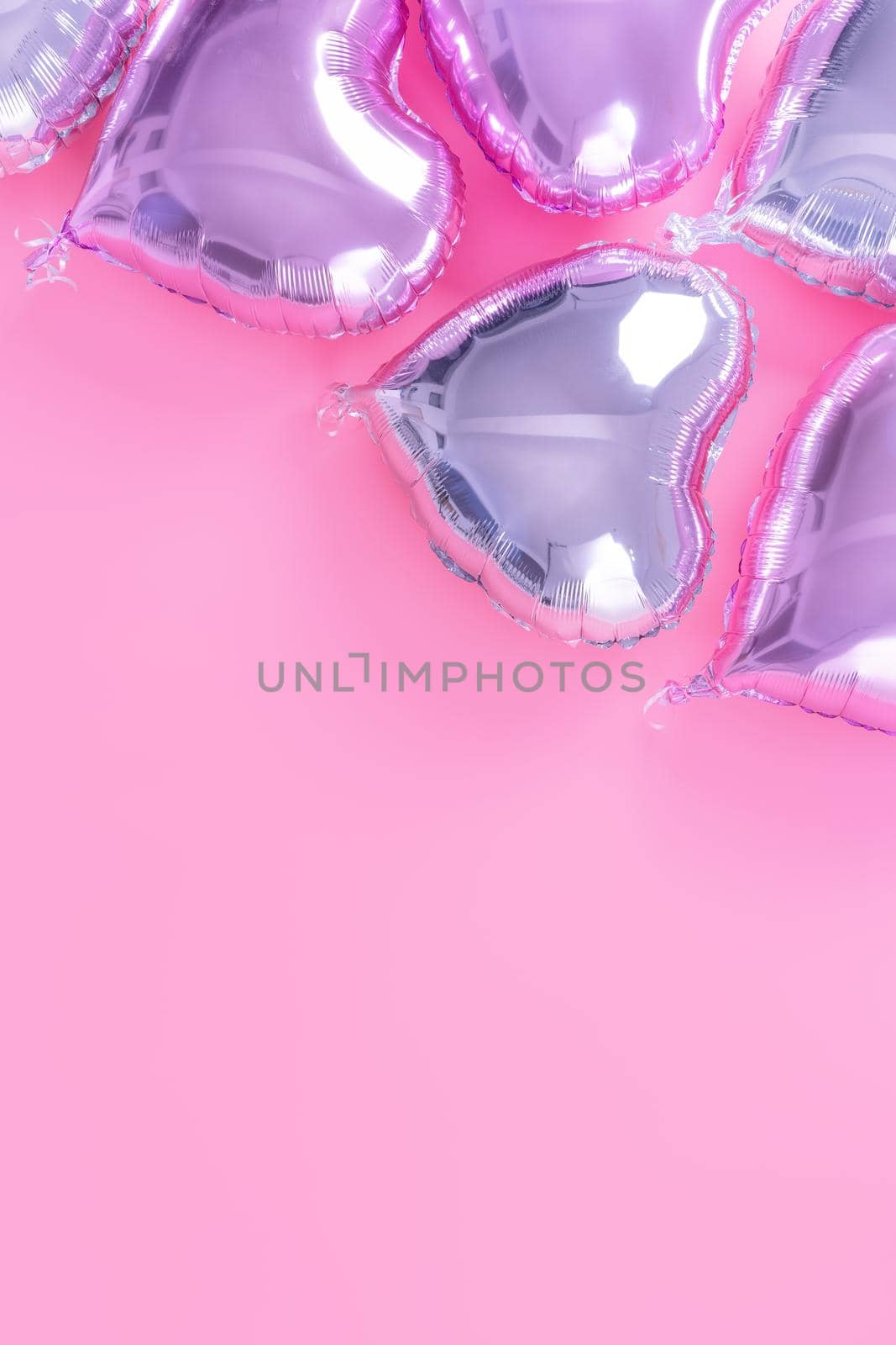 Valentine's Day romantic design concept - Beautiful real heart shape foil balloon isolated on pale pink background, top view, flat lay, overhead above photography.