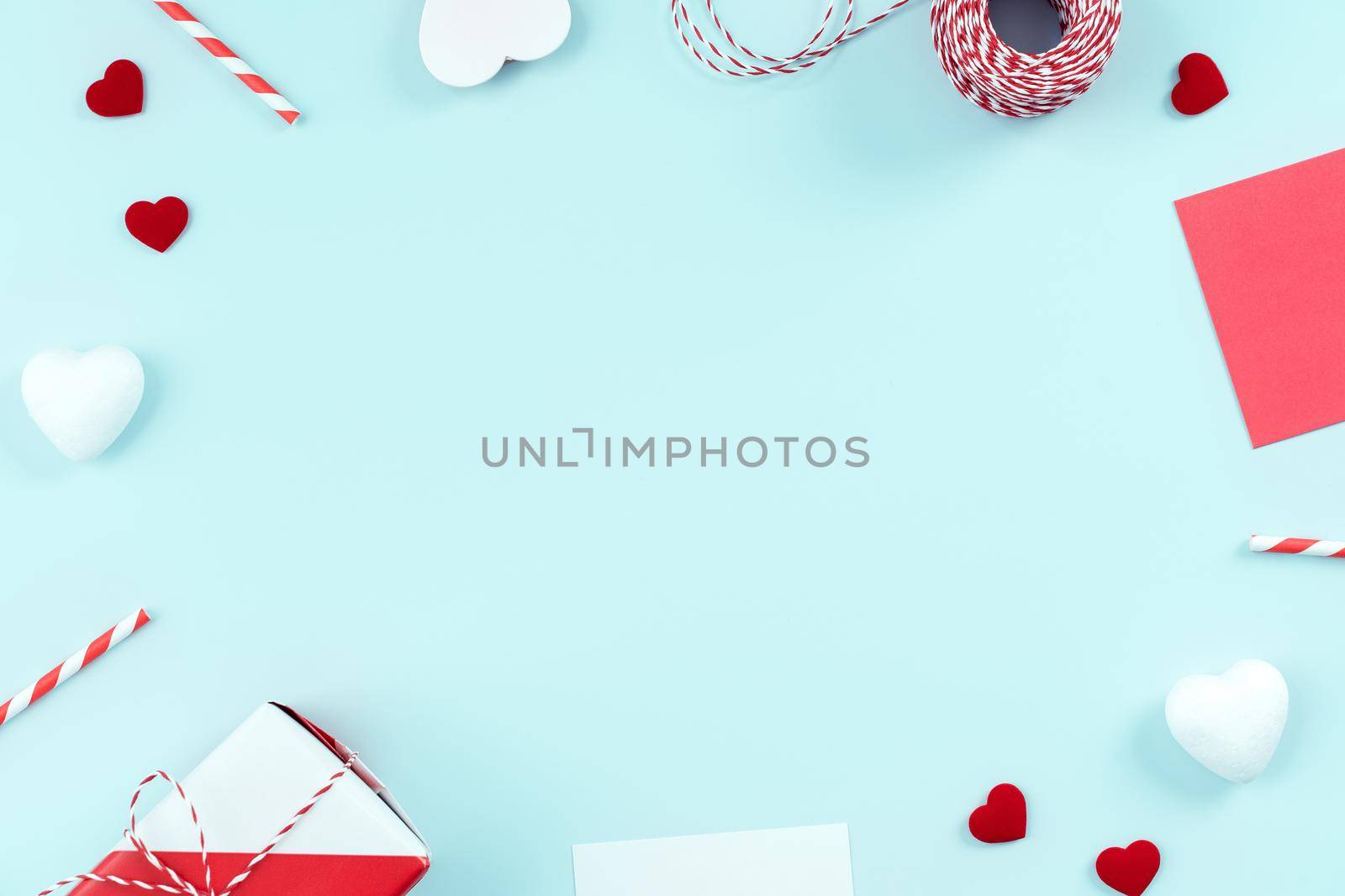 Valentine's Day, Mother's day art design concept for promotion - Red, white wrapped gift box isolated on pastel light blue color background, flat lay, top view.