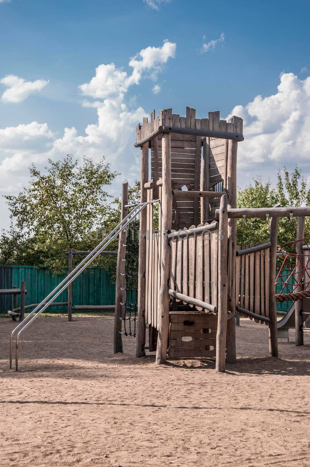 Empty old wood playground in summer day with blue sky and clouds