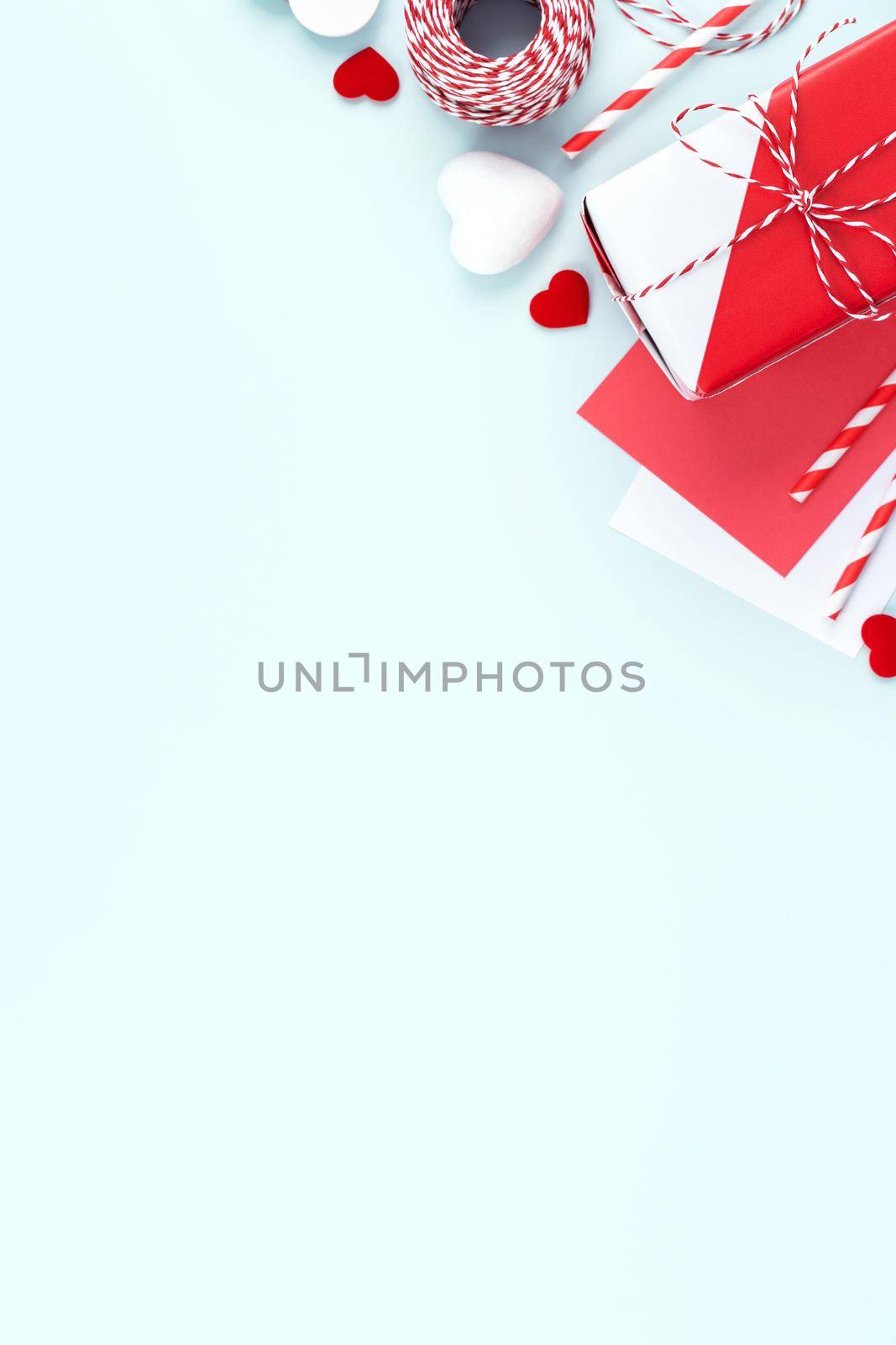 Valentine's Day, Mother's day art design concept for promotion - Red, white wrapped gift box isolated on pastel light blue color background, flat lay, top view.