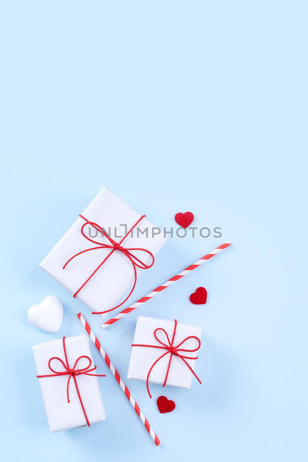 Valentine's Day, Mother's day art design concept for promotion - Red, white wrapped gift box isolated on pastel light blue color background, flat lay, top view.