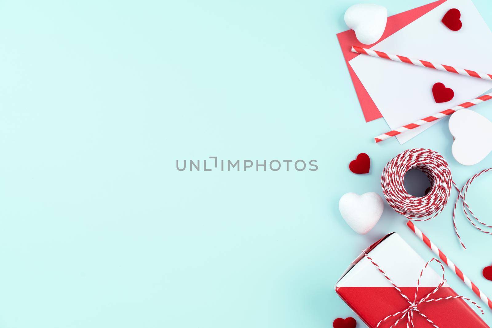 Valentine's Day, Mother's day art design concept for promotion - Red, white wrapped gift box isolated on pastel light blue color background, flat lay, top view.