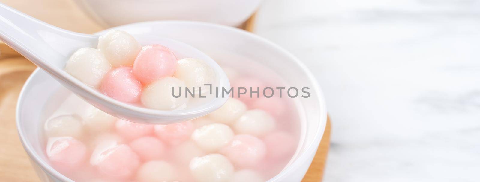 Tang yuan, tangyuan, delicious red and white rice dumpling balls in a small bowl. Asian traditional festive food for Chinese Winter Solstice Festival, close up. by ROMIXIMAGE