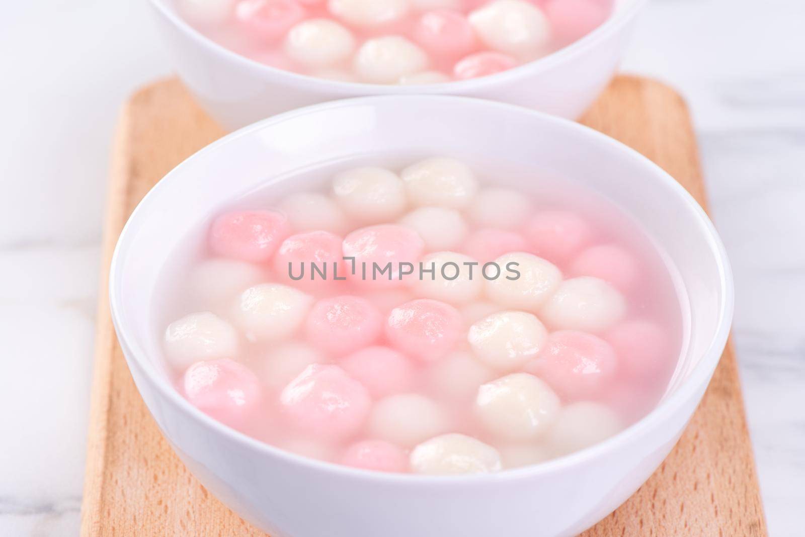 Tang yuan, tangyuan, delicious red and white rice dumpling balls in a small bowl. Asian traditional festive food for Chinese Winter Solstice Festival, close up.