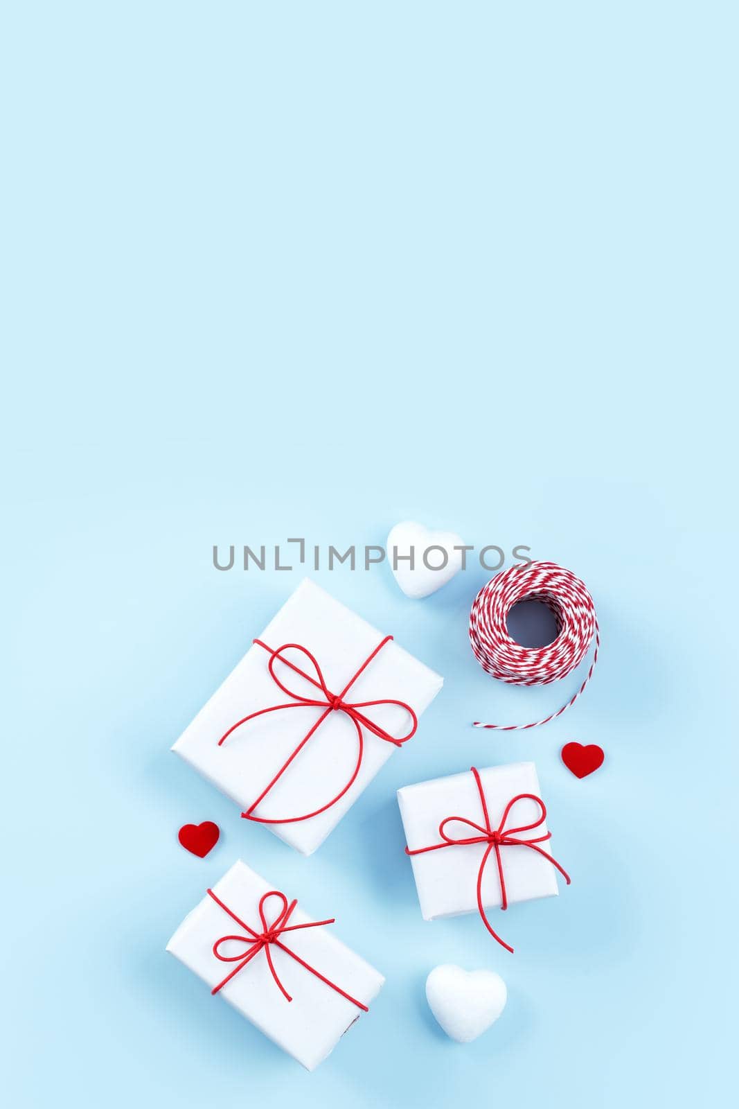 Valentine's Day, Mother's day handmade gift design concept - Wrapped gift box isolated on pastel light blue color background, flat lay, top view. by ROMIXIMAGE