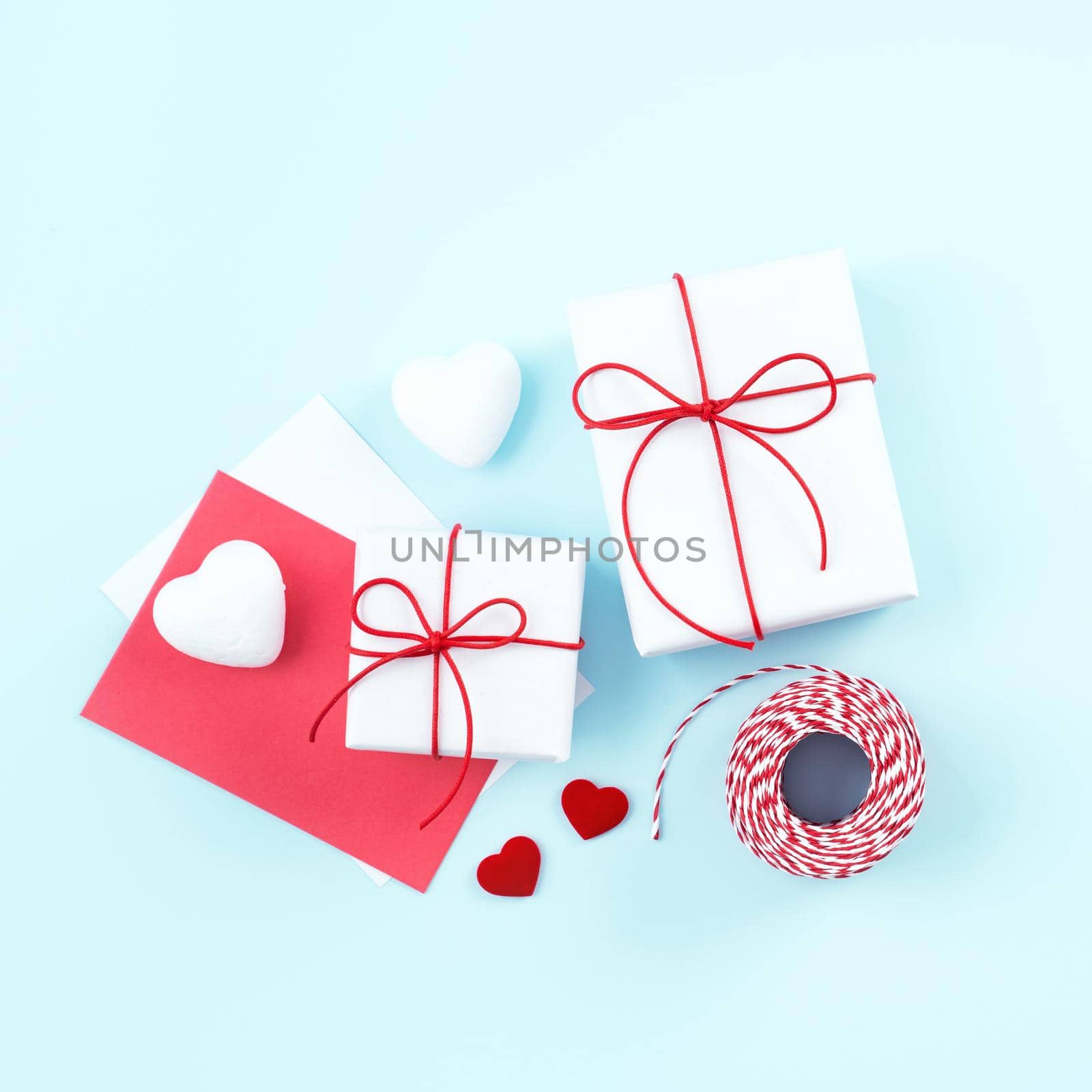 Mother's day, Valentine's Day, handmade gift design concept - Wrapped gift box isolated on pastel light blue color background, flat lay, top view.