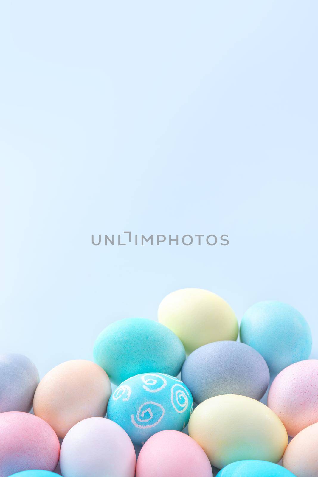 Colorful Easter eggs dyed by colored water isolated on a pale blue background, design concept of Easter holiday activity, close up, copy space. by ROMIXIMAGE