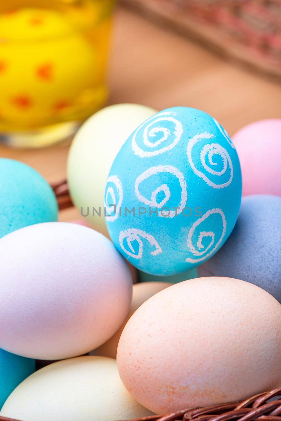 Easter eggs preparation - Young woman is drawing white egg with pastel wax crayon before dyeing colors at home kitchen table, close up, lifestyle by ROMIXIMAGE