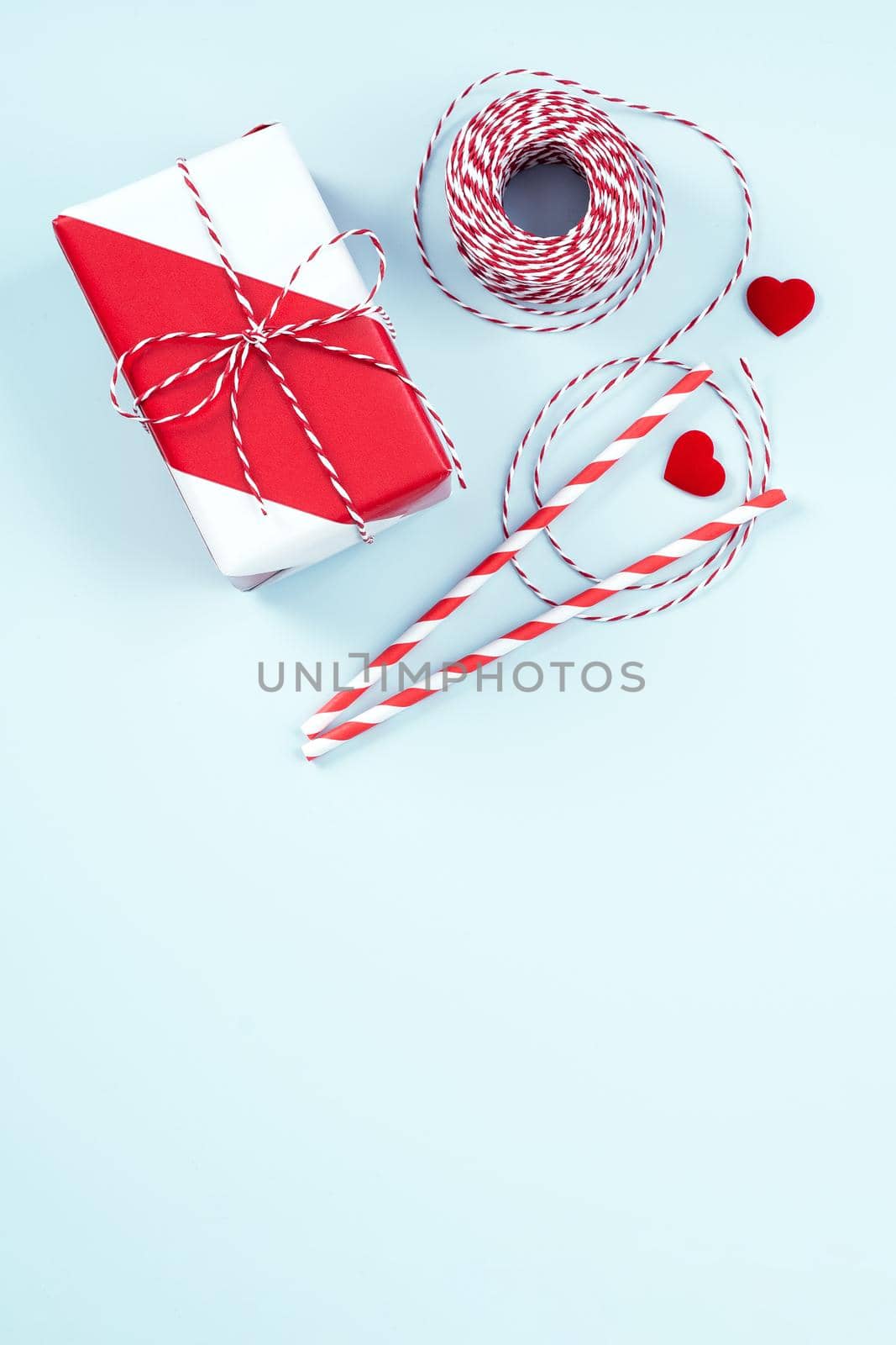 Mother's day, Valentine's Day handmade gift design concept - Wrapped gift box isolated on pastel light blue color background, flat lay, top view.