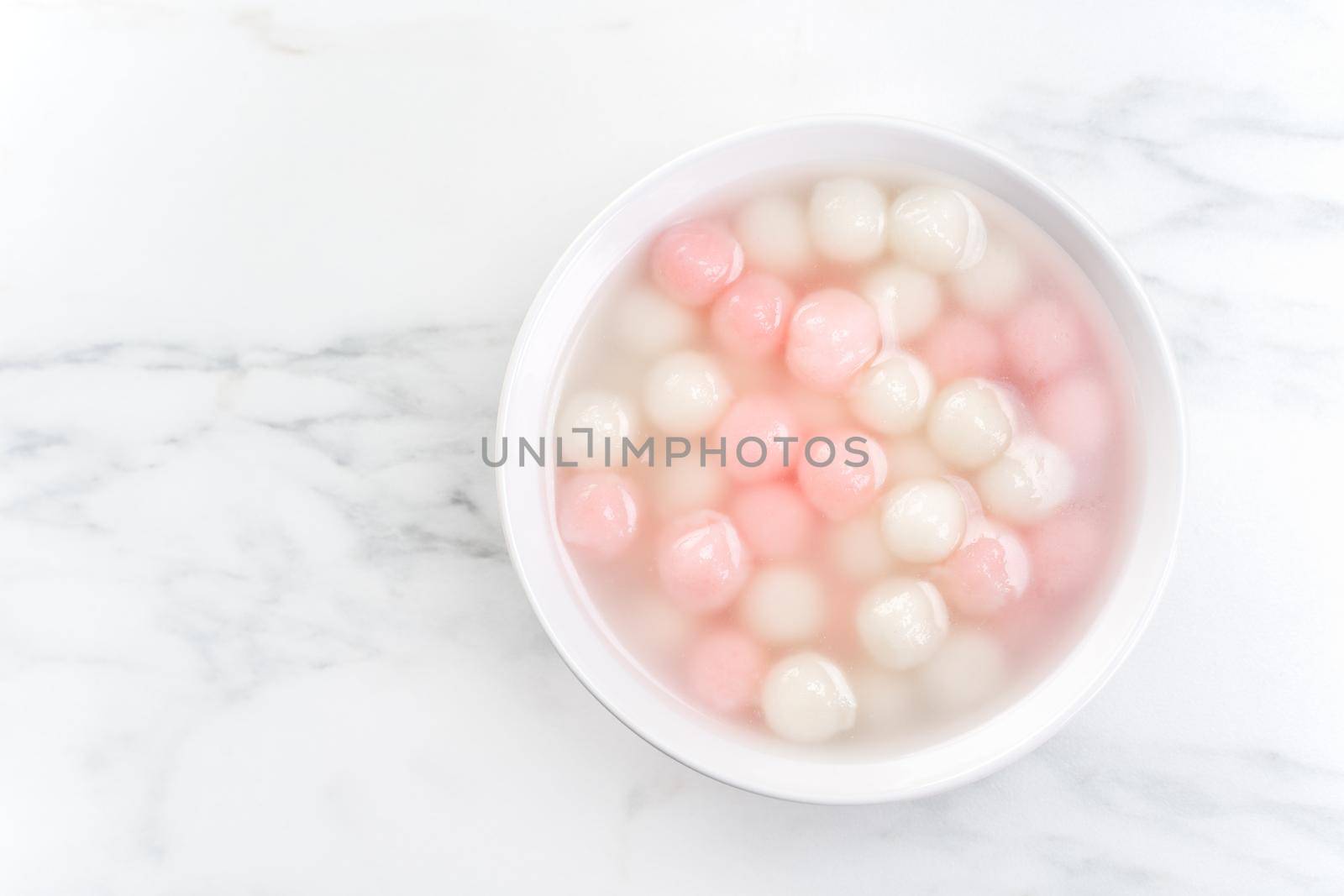 Tang yuan, tangyuan, delicious red and white rice dumpling balls in a small bowl, top view, flat lay. Asian festive food for Winter Solstice Festival.