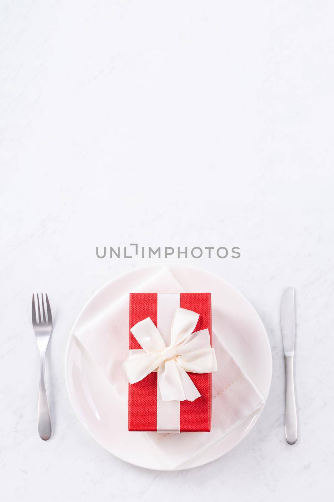 Valentine's Day, Mother's Day, holiday dating meal, banquet design concept - White plate and red ribbon on marble background, top view, flat lay.