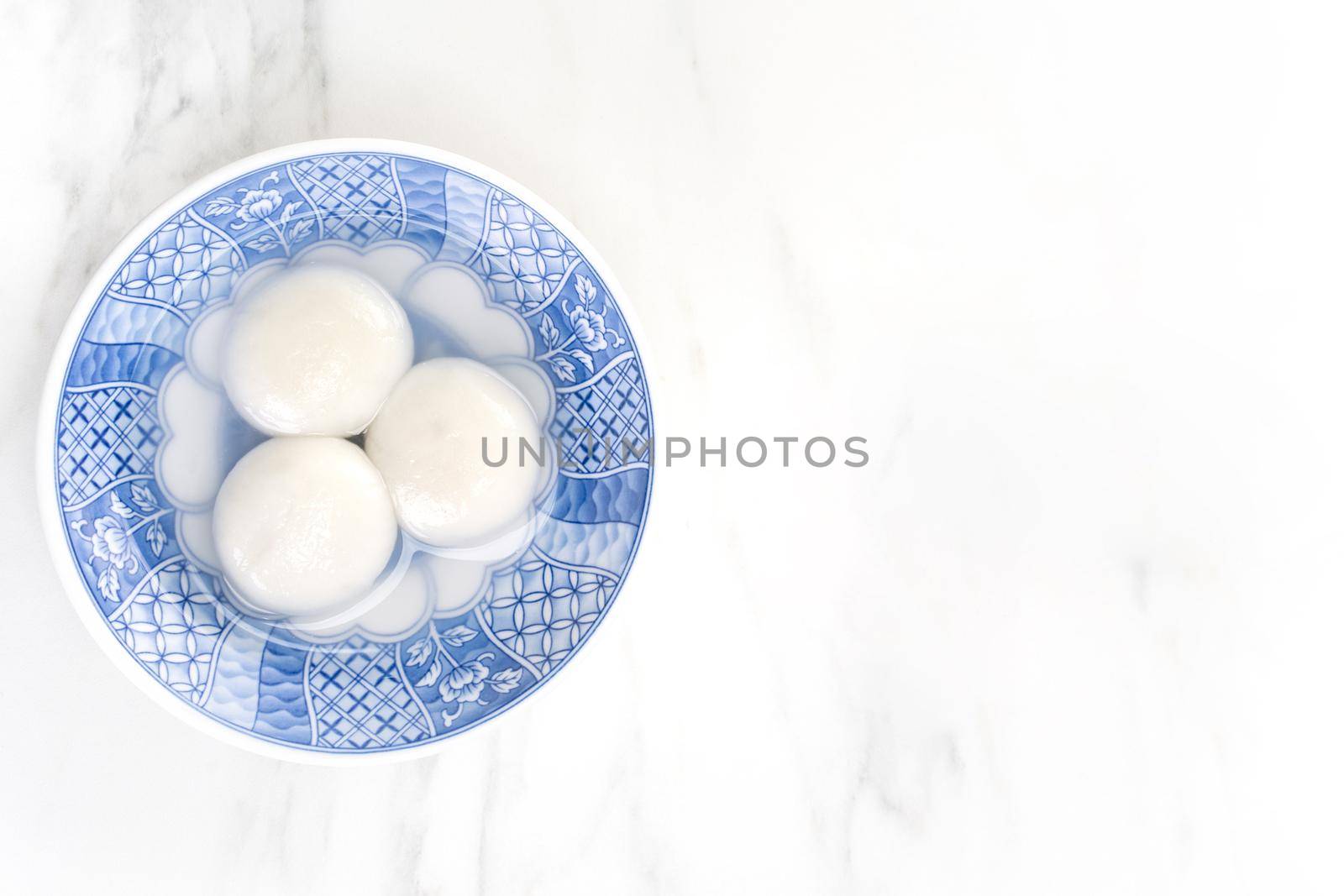 Tang yuan, tangyuan, yuanxiao in a small bowl stuffed with sesame fillings, top view, flat lay. Delicious asian food rice dumpling balls for festival. by ROMIXIMAGE