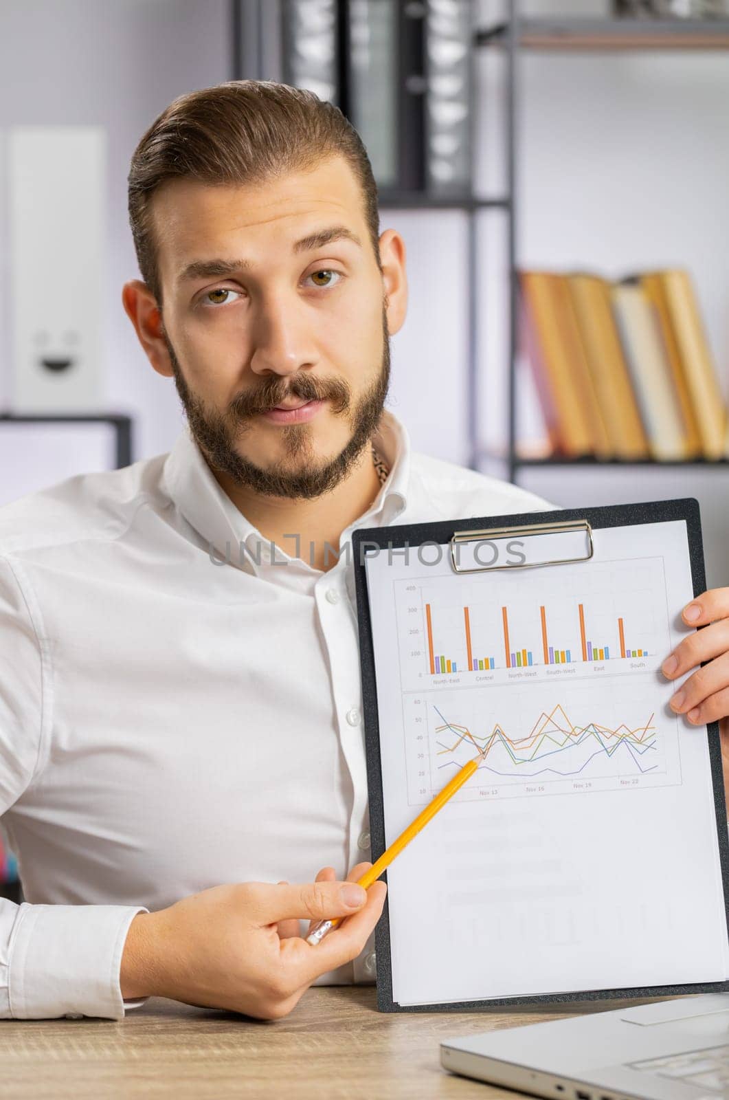 Young boss business man making online presentation video call, demonstrates graphic analytics, planning budget, statistic. Freelancer guy at office workplace looking at camera, talking. Vertical shot