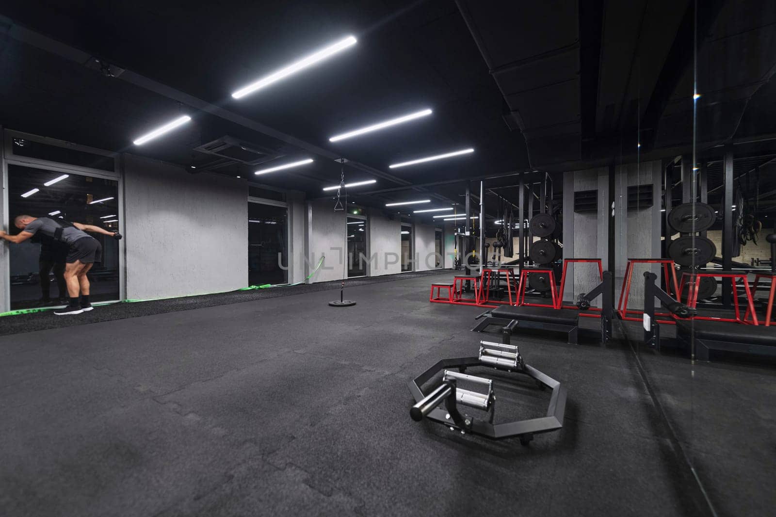 An empty modern gymnasium with a variety of equipment, offering a spacious, functional, and well-equipped training facility for workouts, fitness, and strength training.