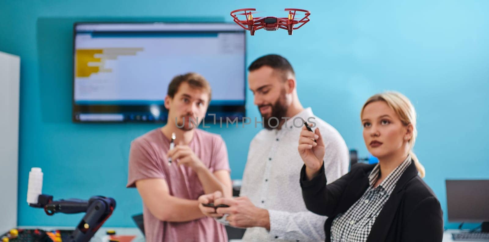 A group of students working together in a laboratory, dedicated to exploring the aerodynamic capabilities of a drone.