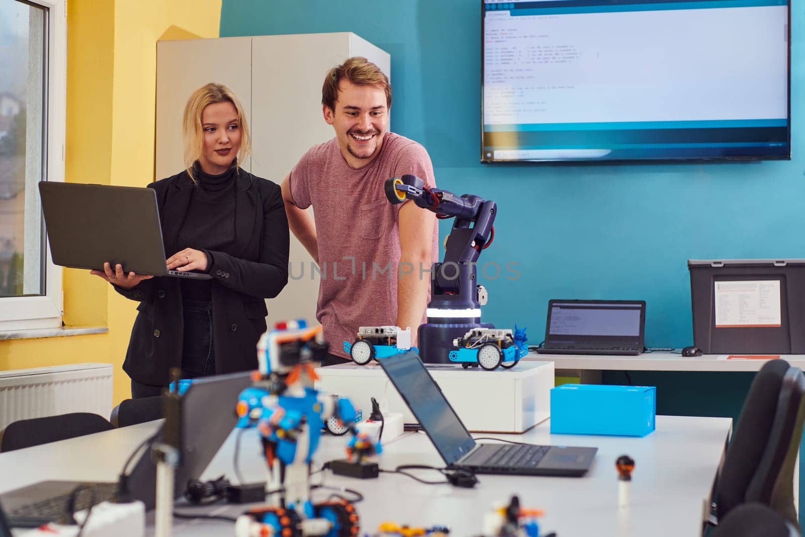 A group of colleagues working together in a robotics laboratory, focusing on the intricate fields of robotics and 3D printing. Showcase their dedication to innovation, as they engage in research, development, engineering, and precision work.