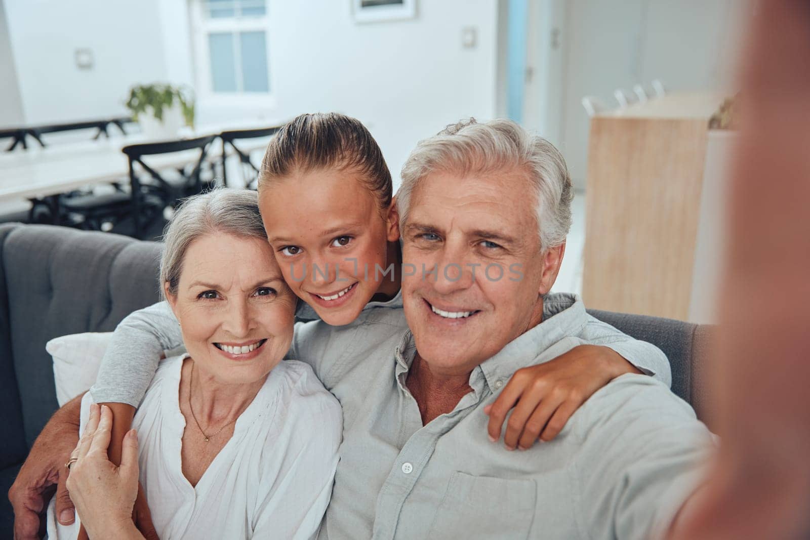 Family, love and selfie on sofa in home, having fun and bonding. Hug, portrait and grandpa, grandmother and girl taking pictures for profile picture, social media and happy memory together in house.