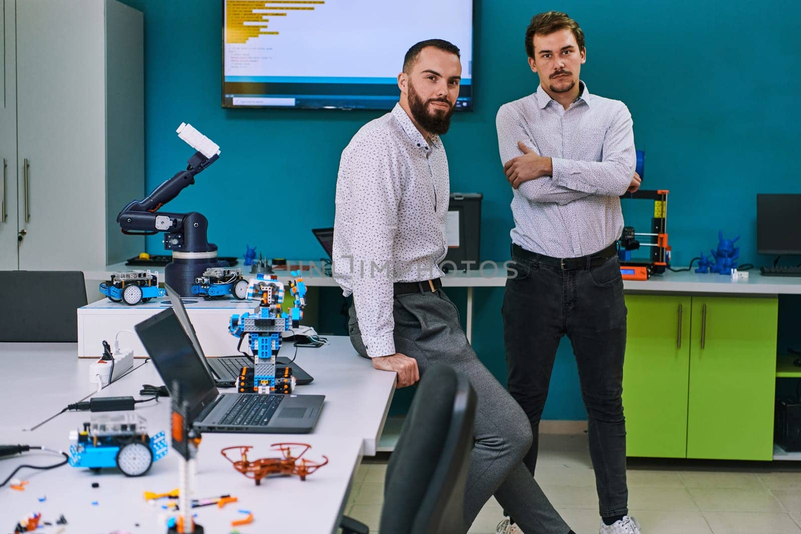 A group of colleagues collaborate in a lab while testing a 3D printer, demonstrating their commitment to technological advancement and scientific research