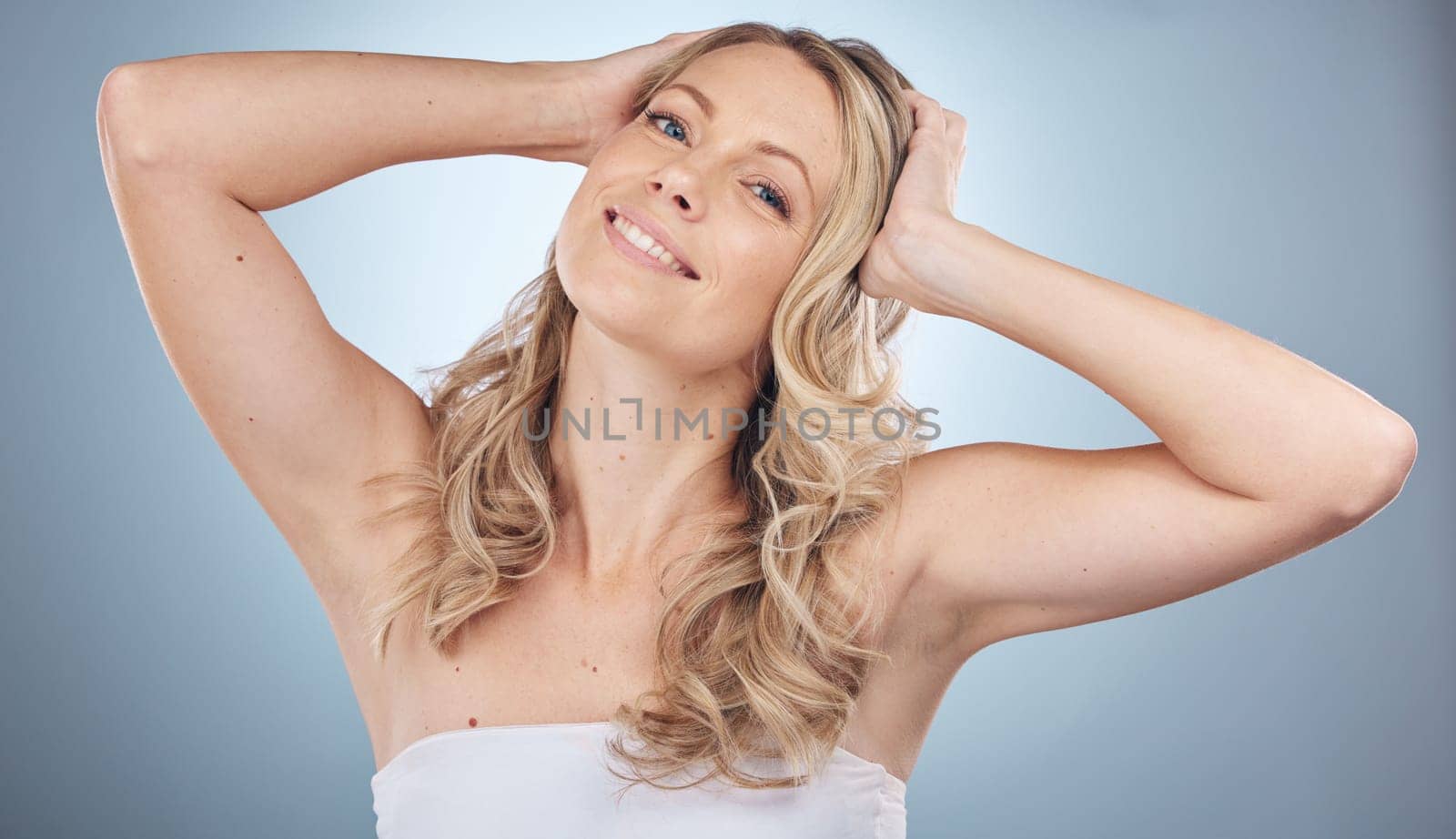 Hair care, portrait and beauty of woman in studio isolated on gray background. Skincare, cosmetics and face of female model with curly hairstyle after salon treatment for growth, balayage or texture