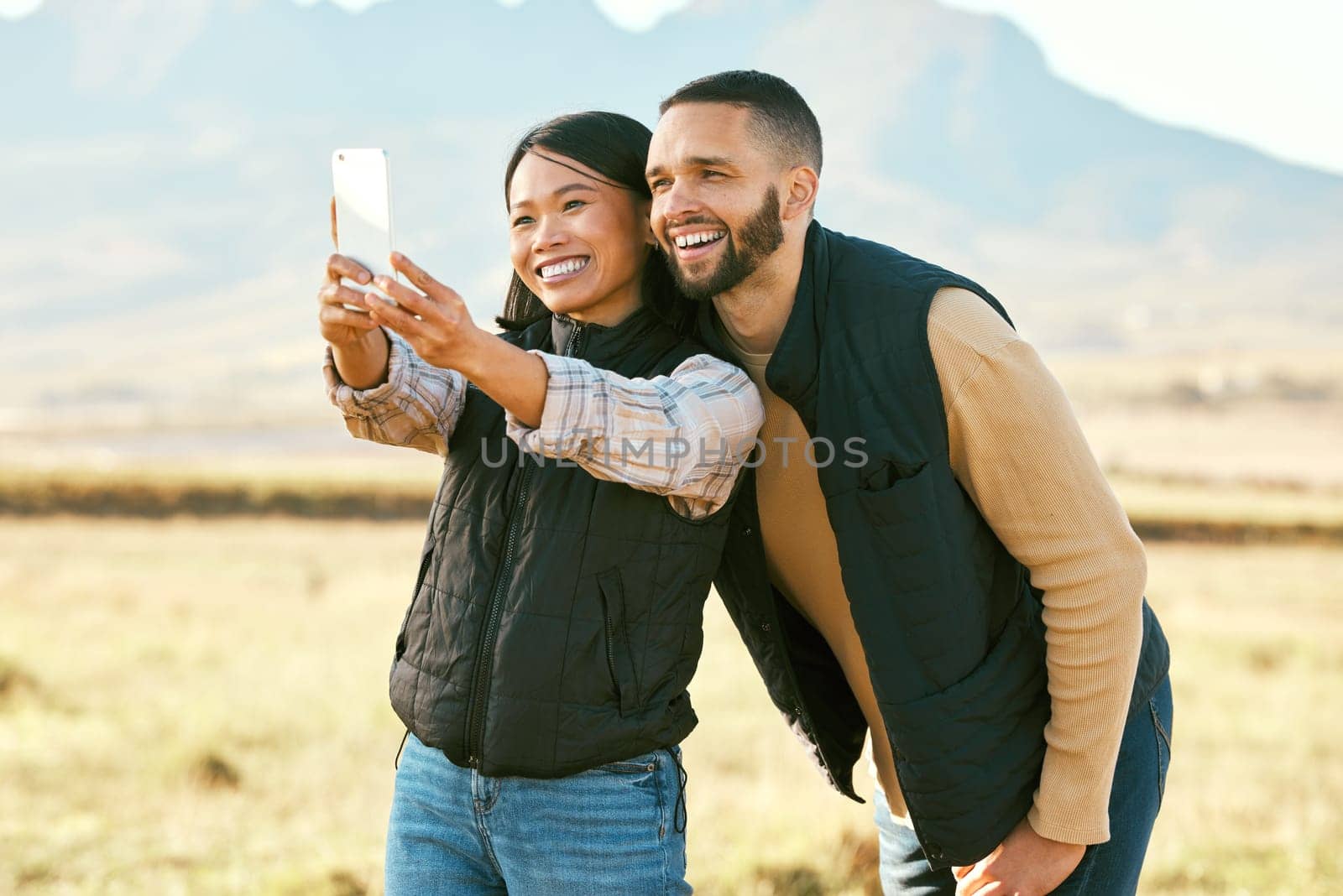 Selfie, couple and travel to countryside, outdoor and happy with phone for photography on holiday in outback Australia. Memory, smile in picture and smartphone, adventure and happiness with freedom