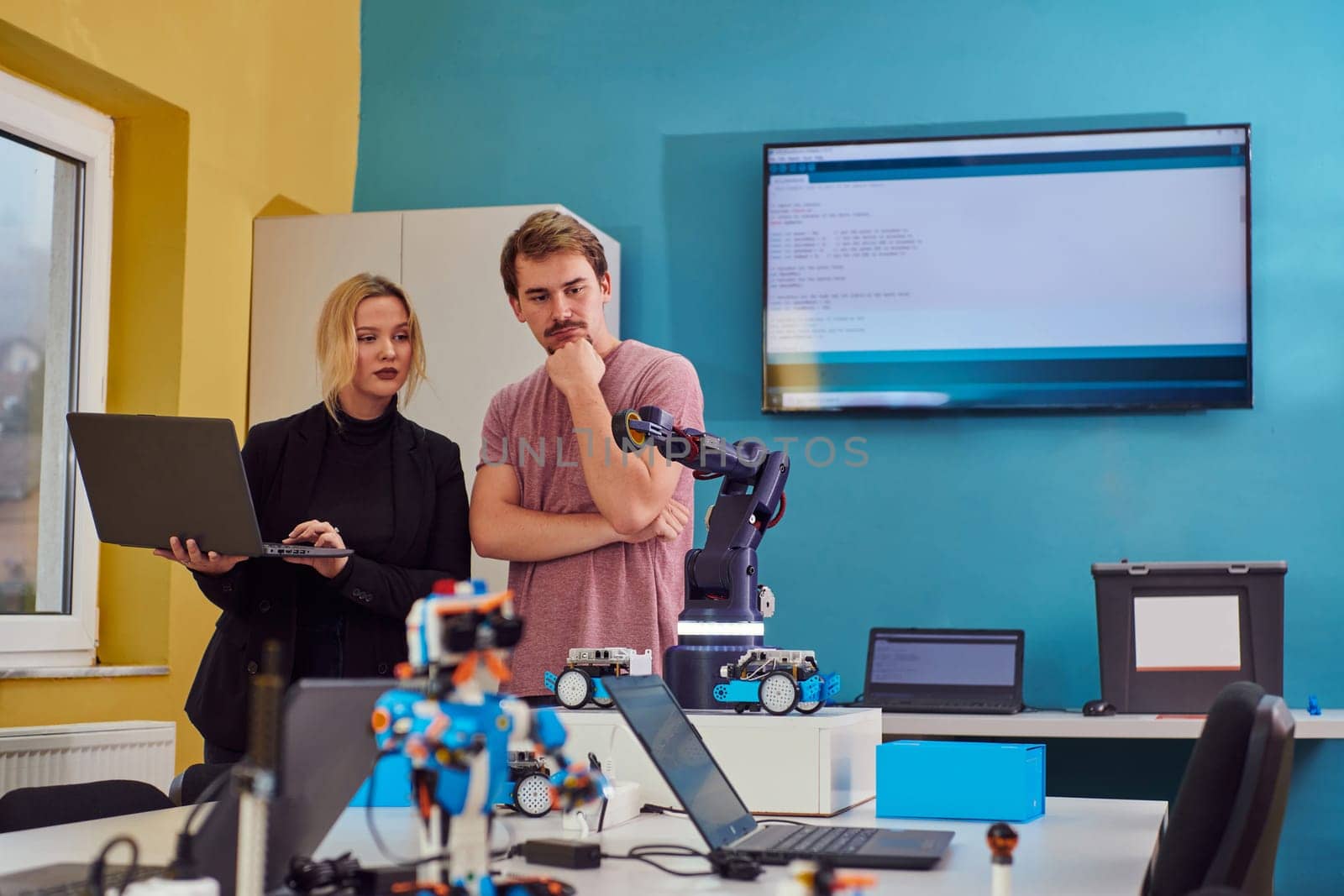 A group of colleagues working together in a robotics laboratory, focusing on the intricate fields of robotics and 3D printing. Showcase their dedication to innovation, as they engage in research, development, engineering, and precision work by dotshock