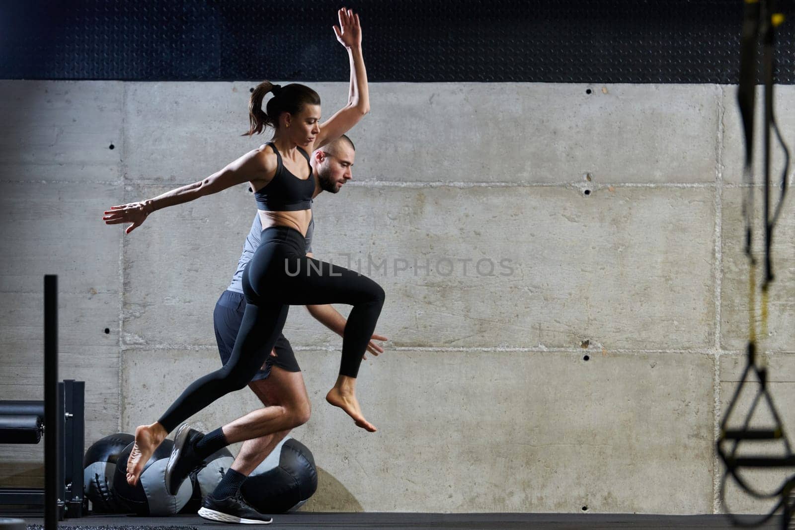 A fit couple exercising various types of jumps in a modern gym, demonstrating their physical fitness, strength, and athletic performance by dotshock