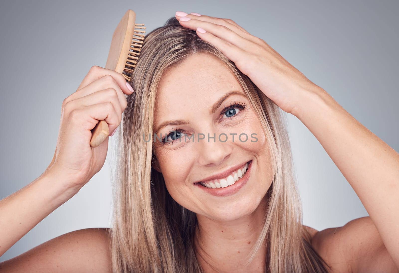Portrait, comb or woman with hair care, shine or salon treatment with girl on grey studio background. Face, female or lady brushing scalp, luxury or grooming routine for texture or volume on backdrop.