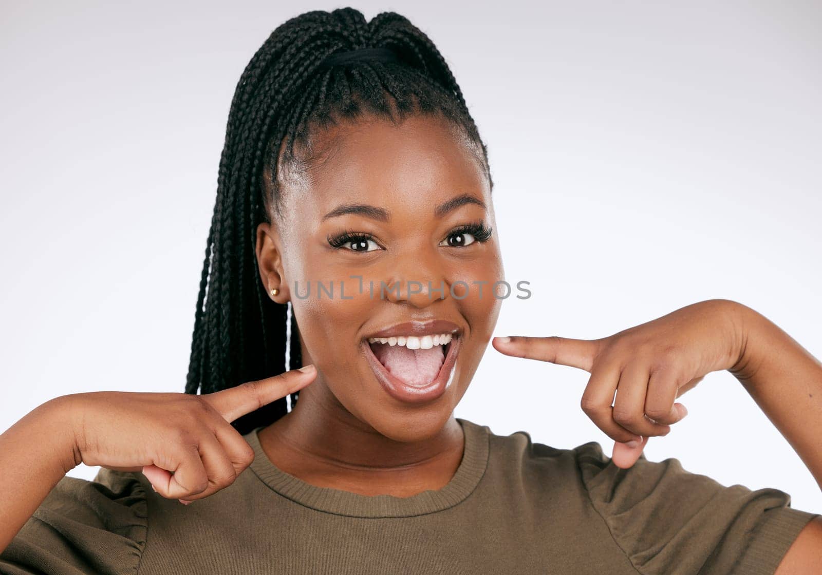 Portrait, dental and a black woman pointing to her mouth in studio on a gray background for oral hygiene. Face, teeth and an attractive young female inside to point at her teeth for whitening.