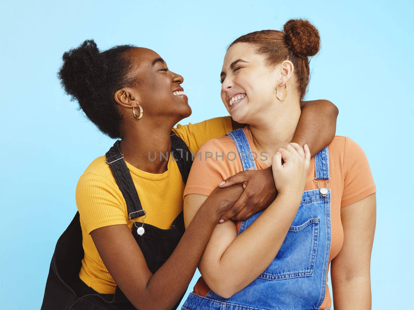 Hug, lesbian women and couple with happiness, young and gen z with lgbt, fashion and marketing with love against studio background. Happy lgbtq community, fun and freedom with style and pride.