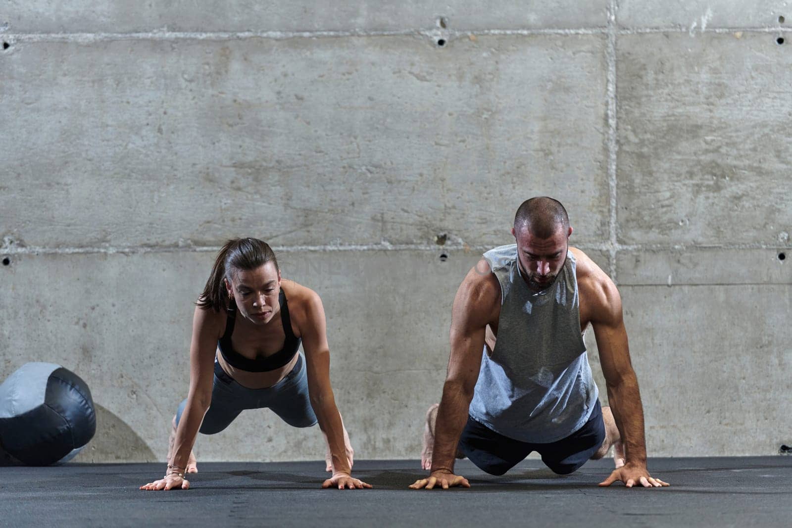 An attractive couple in the gym engaging in various stretching exercises together, showcasing their dedication to fitness, flexibility, and overall well-being. With synchronized movements, they demonstrate coordination, balance, and endurance while supporting and motivating each other on their fitness journey by dotshock