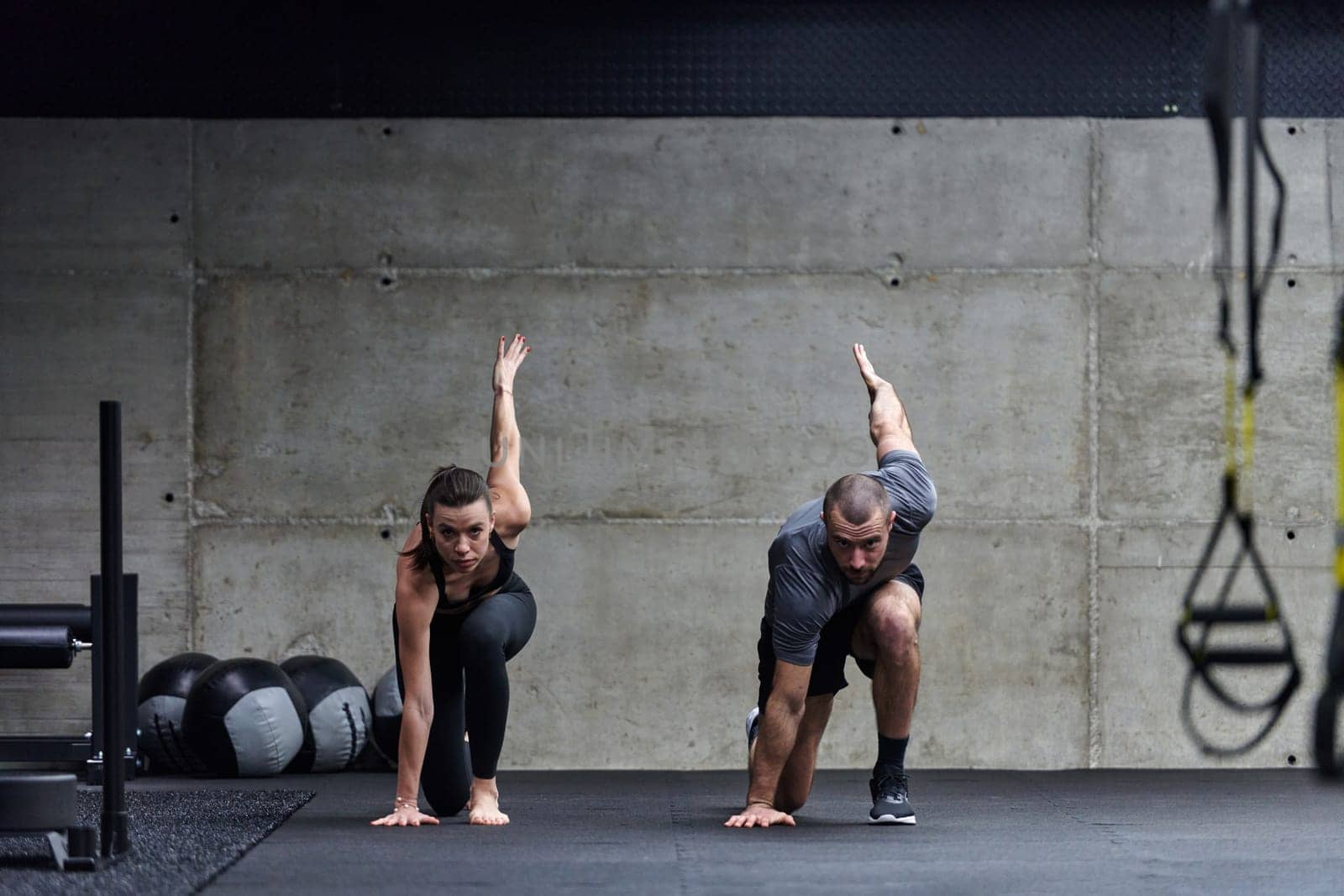 A fit couple in a modern gym, engaging in running exercises and showcasing their athletic prowess with a dynamic start