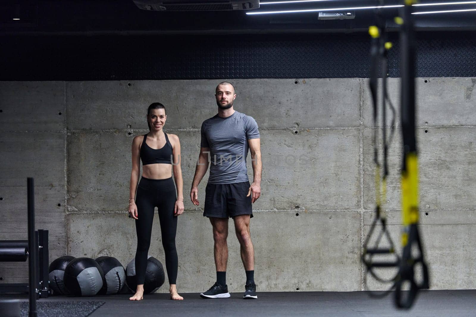 Muscular man and fit woman in a conversation before commencing their training session in a modern gym