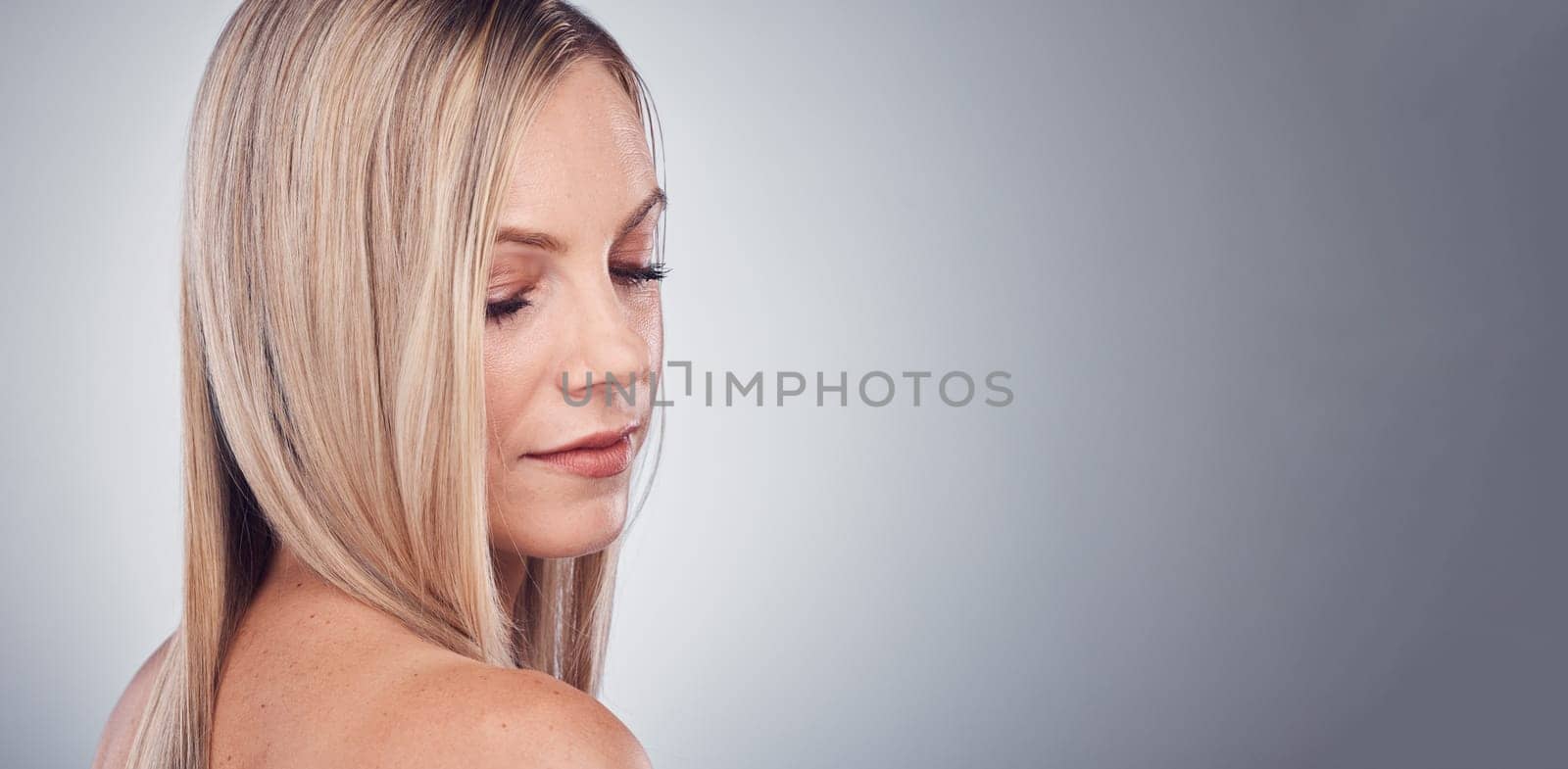 Beauty, hair care and woman with space for studio mockup with natural makeup cosmetics and shampoo for shine. Face of aesthetic model person on grey background for hairdresser or salon product logo.