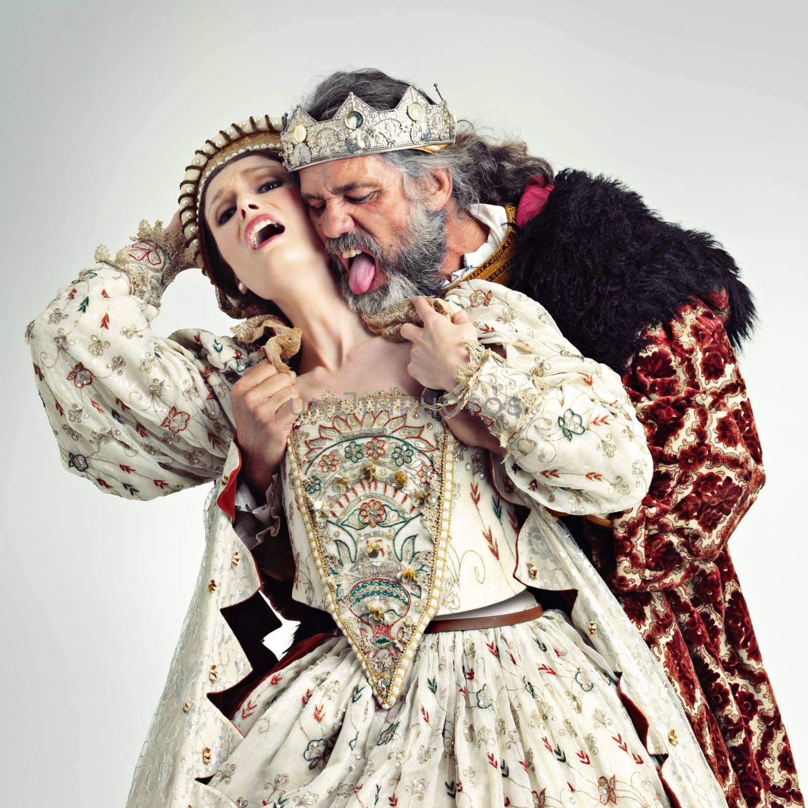 King, queen and love of couple in studio isolated on a gray background. Vintage royalty, retro victorian and affection, romance and passion of royal man and woman with crown kissing, embrace and hug