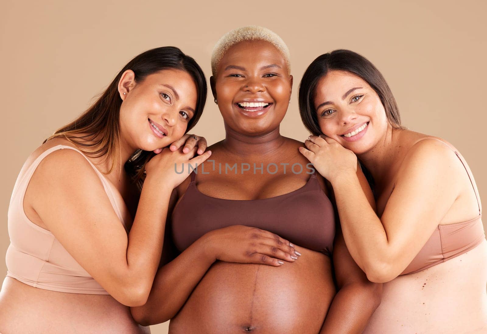 Portrait, beauty and happy with pregnant friends in studio on a beige background for diversity or motherhood. Family, love and pregnancy with a woman friend group showing their baby bump stomach by YuriArcurs