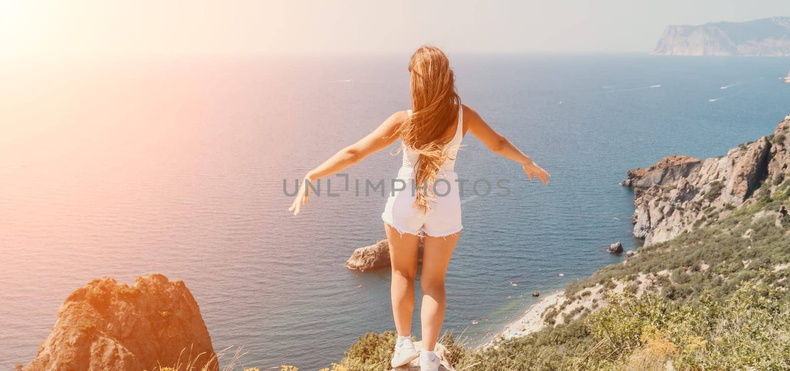 Woman summer travel sea. Happy tourist enjoy taking picture outdoors for memories. Woman traveler posing over sea bay surrounded by volcanic mountains, sharing travel adventure journey by panophotograph