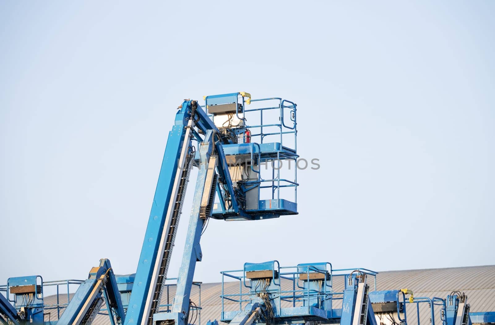 Articulated boom lift. Aerial platform lift. Telescopic boom lift against clear sky. Mobile construction crane for rent and sale. Maintenance and repair hydraulic boom lift service. Crane dealership. by Fahroni