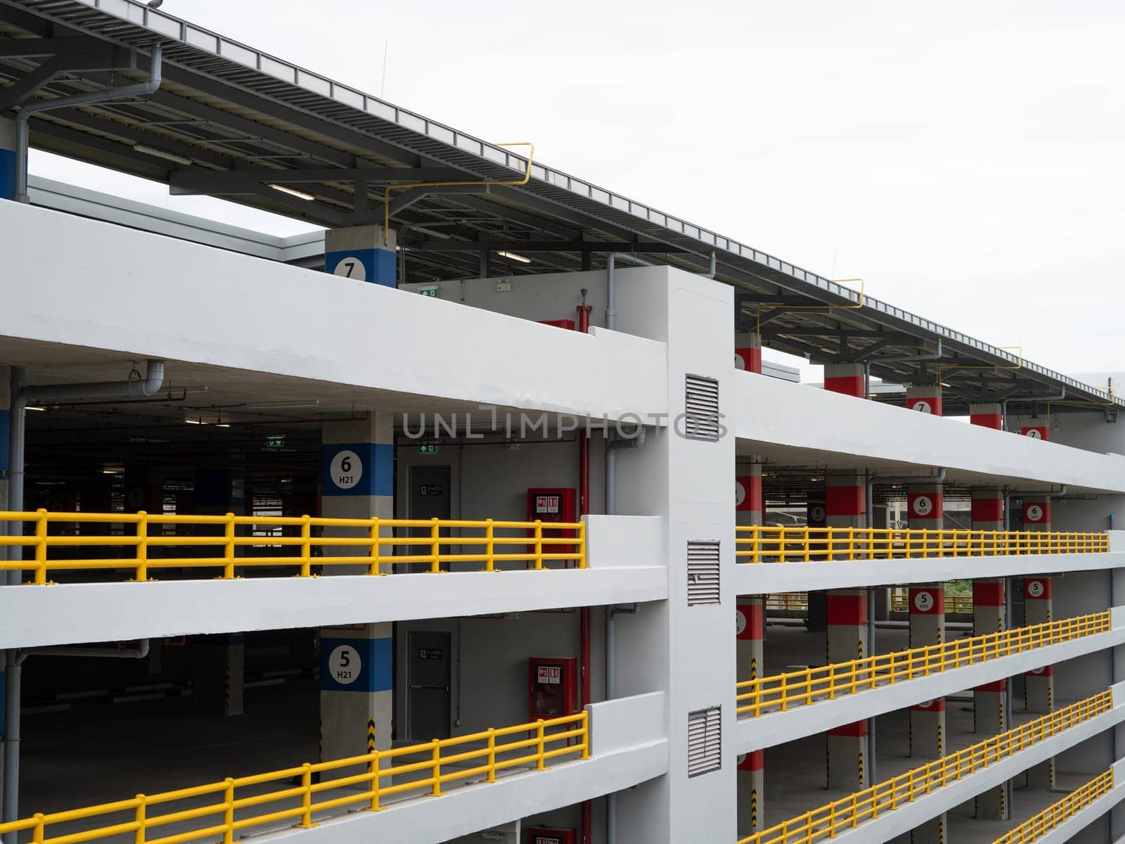 Multi-level parking garage. Indoor car park building. Urban parking structure. Multistory car park. Concrete parking garage. Vehicle parking facility. Building construction. Modern architecture.