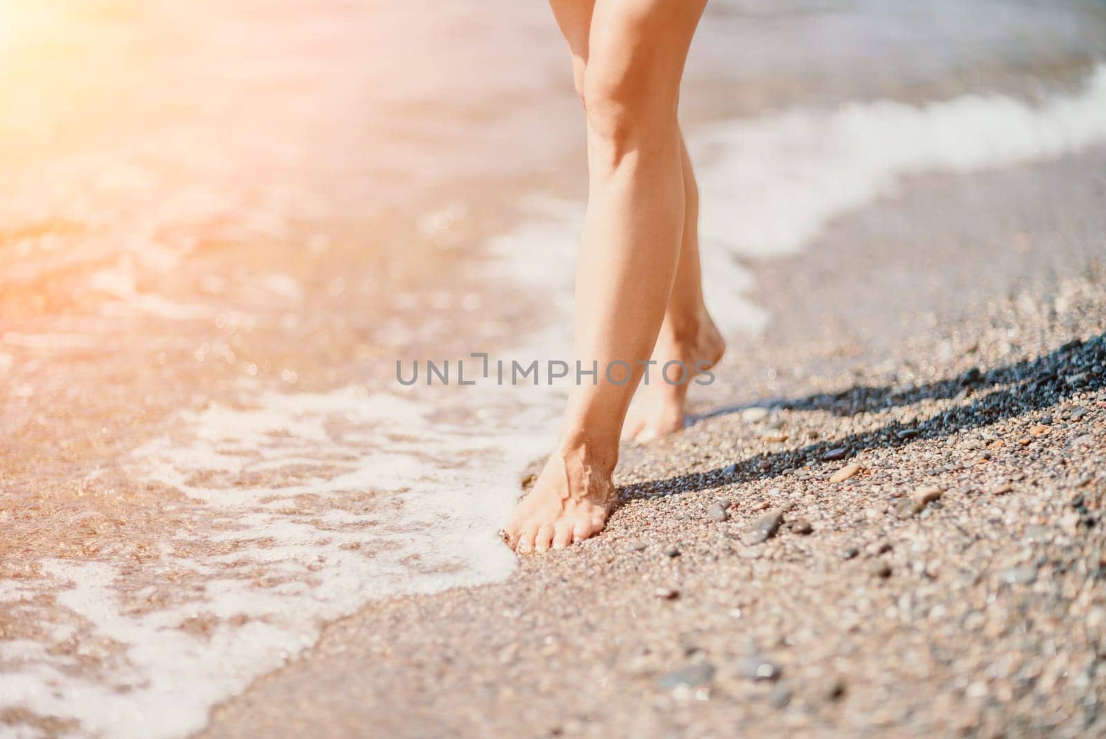 Barefoot woman standing in sea, summer vacation on beach resort. Naked female legs in transparent calm water