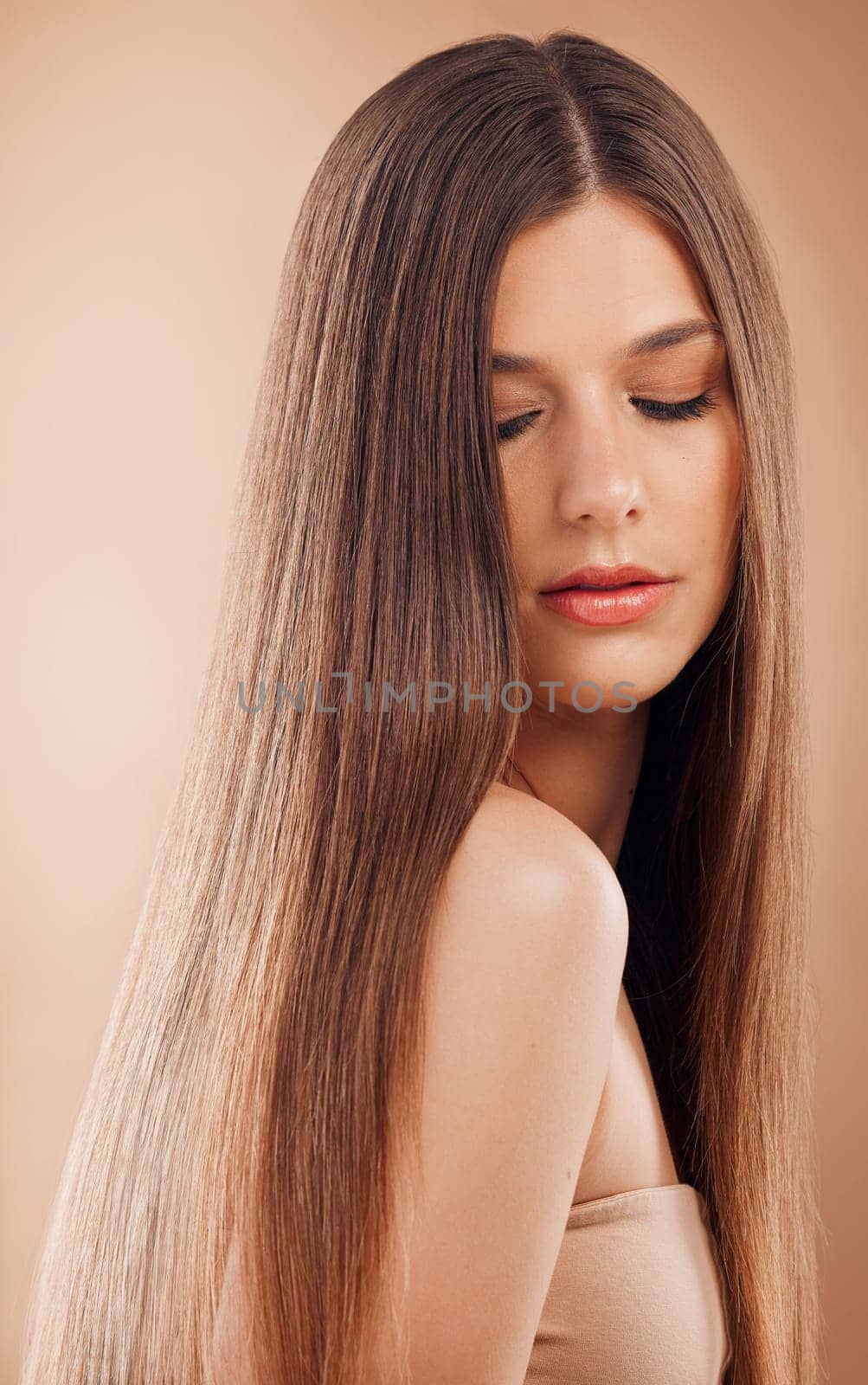 Hair care, beauty and woman on studio background for cosmetics, makeup and shampoo for shine, growth and strong texture hairstyle. Face of brunette posing for hairdresser or luxury salon product.