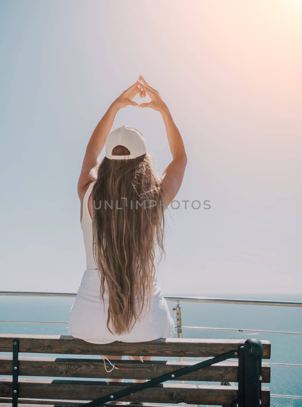 Woman summer travel sea. Happy tourist enjoy taking picture outdoors for memories. Woman traveler posing over sea bay surrounded by volcanic mountains, sharing travel adventure journey by panophotograph