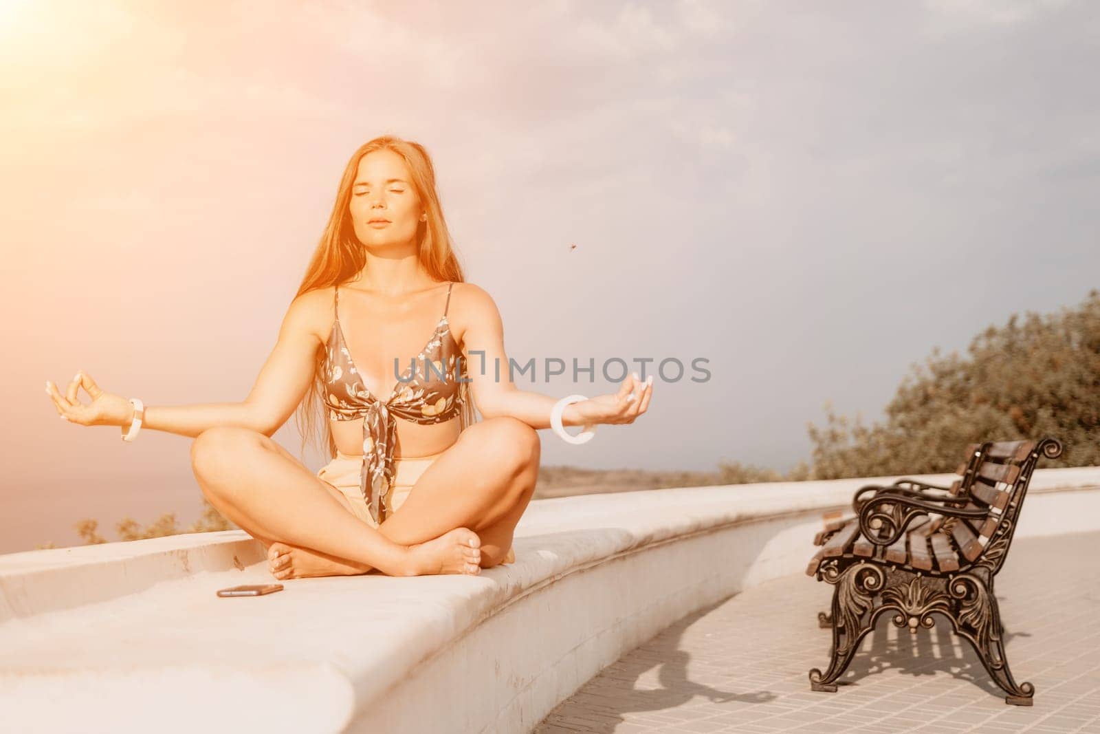 Woman park yoga. Side view of free calm bliss satisfied woman with long hair standing in morning park with yoga position against of sky by the sea. Healthy lifestyle outdoors in park, fitness concept