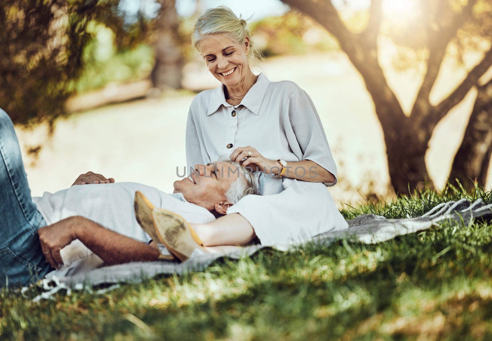 Retirement, love and picnic with a senior couple outdoor in nature to relax on a green field of grass together. Happy, smile and date with a mature man and woman bonding outside for romance.
