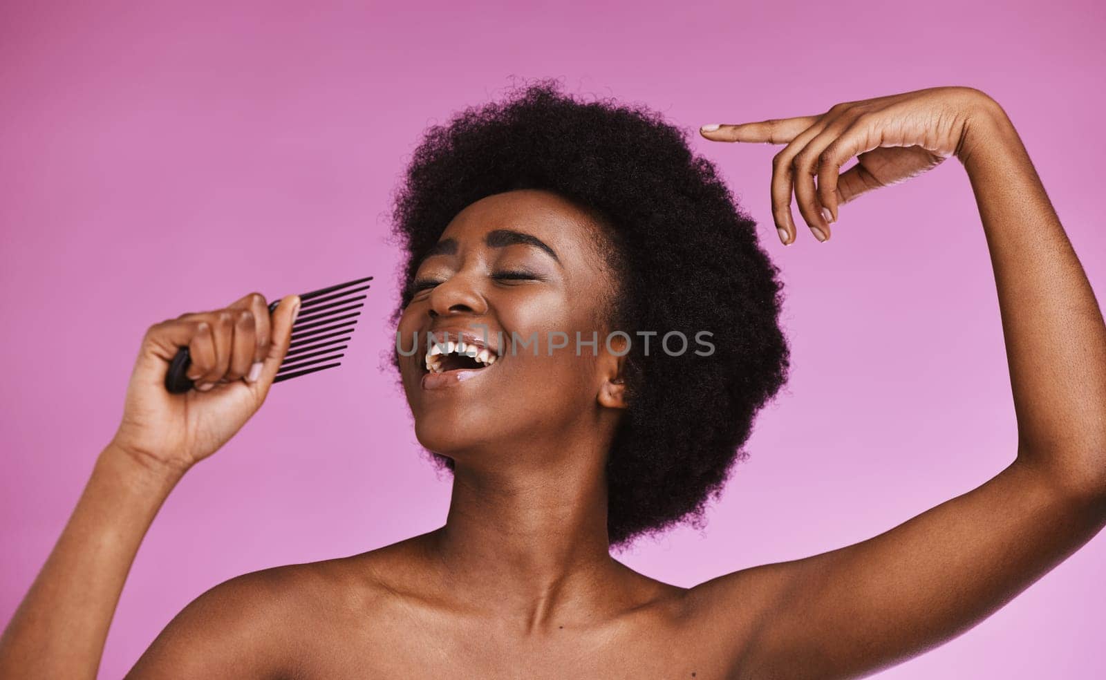Singing black woman, hair or afro comb on background in fun grooming routine, natural skincare play or growth texture karaoke. Beauty, happy or hairstyle brush microphone on isolated pink performance by YuriArcurs